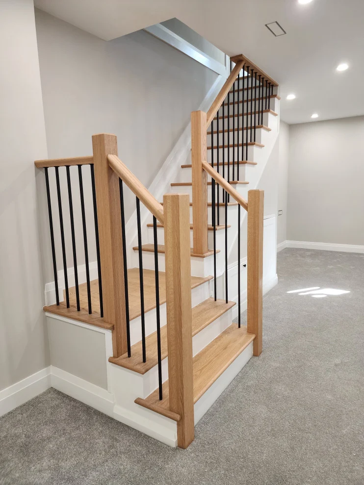 New basement staircase with oak treads, oak newel posts, black metal spindles and grey carpet
